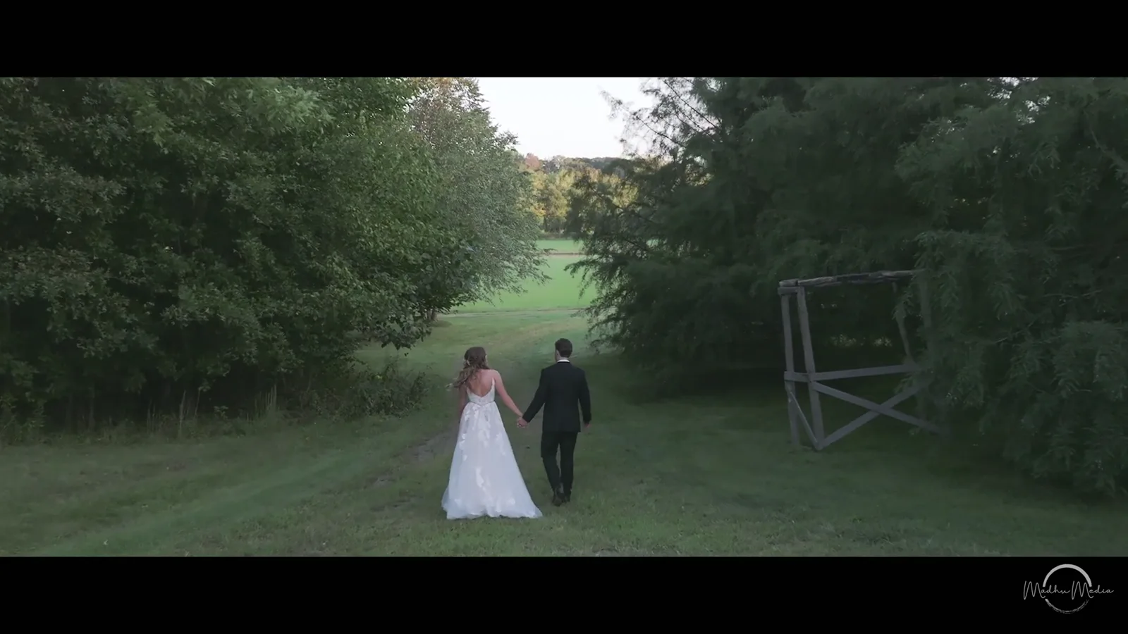 Alexis and Elijah walking through a green field