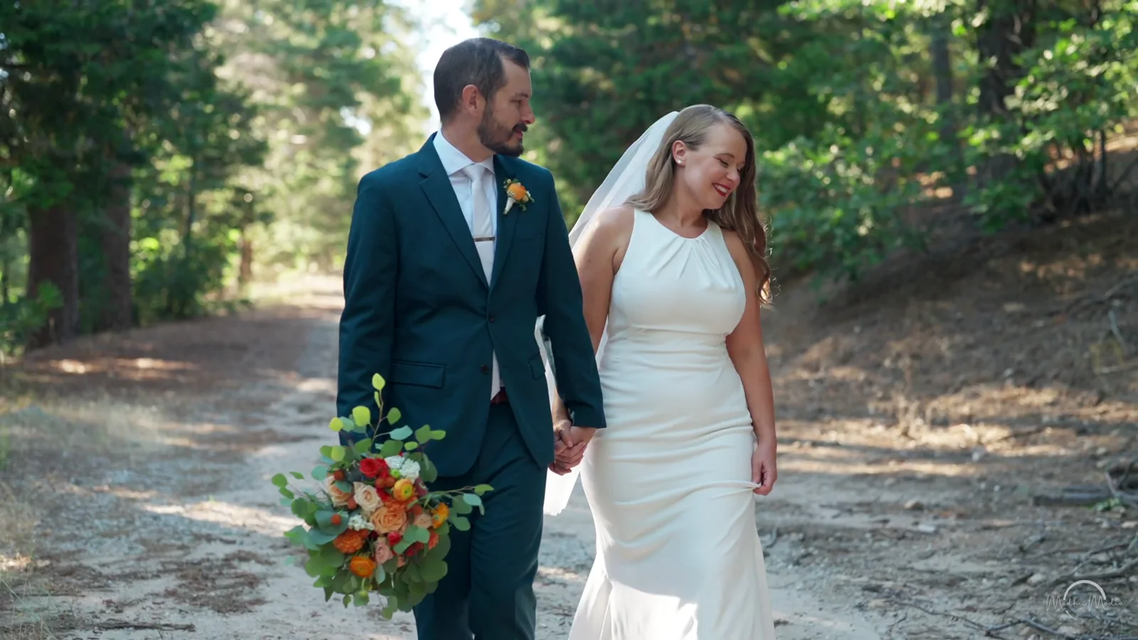 Brandon and Stephanie walking a forest path after their ceremony