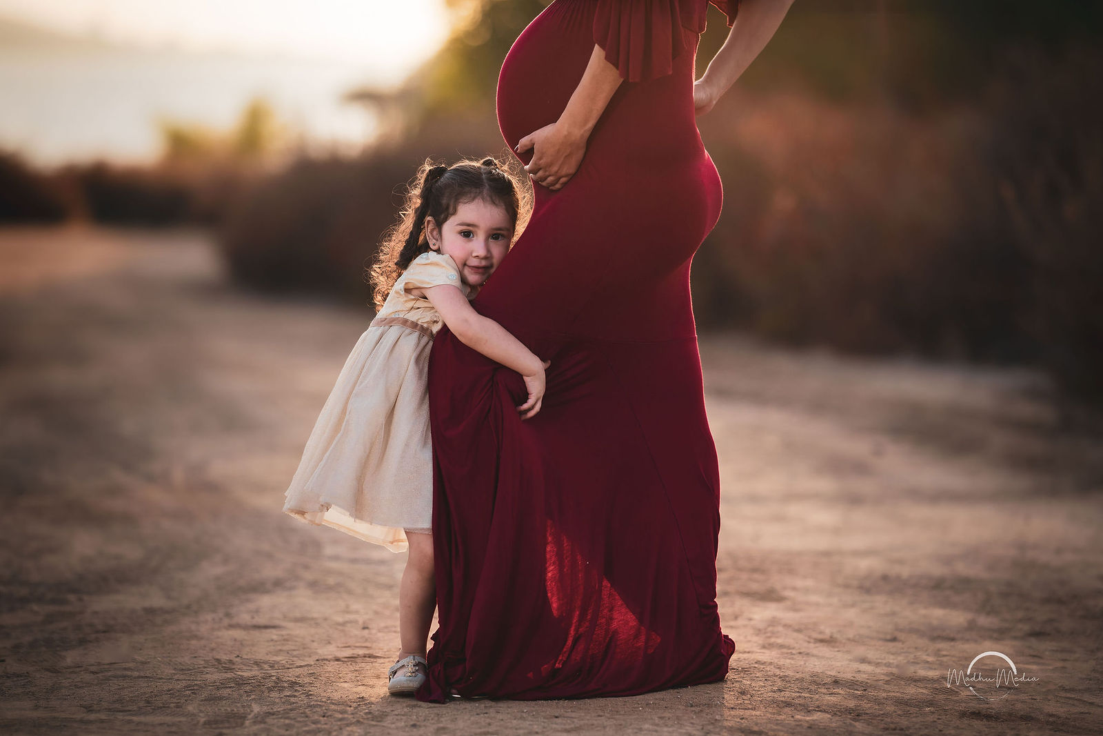 Maternity session at sunset, her daughter hugging the bump