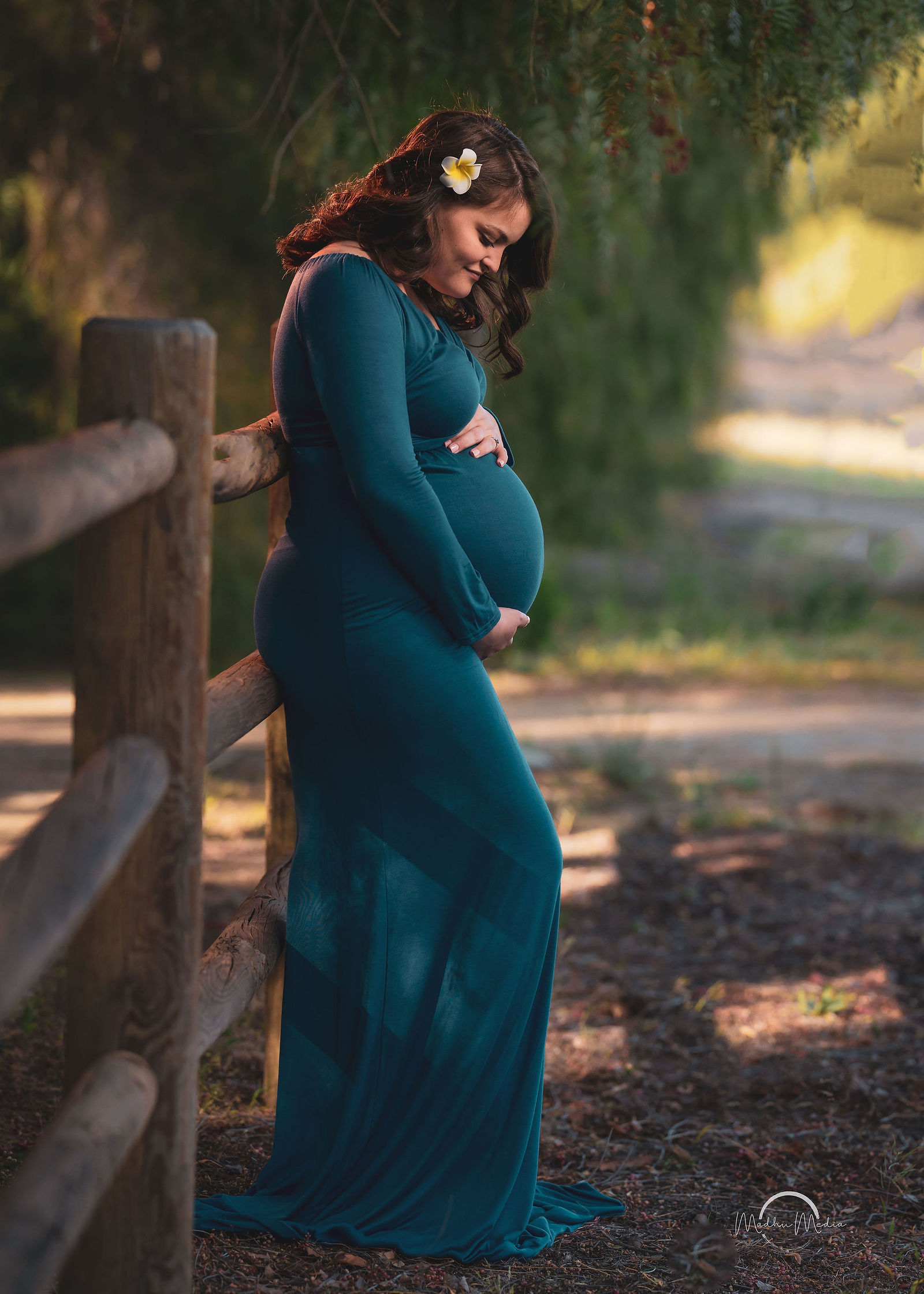 Maternity portrait in teal by the rail fence