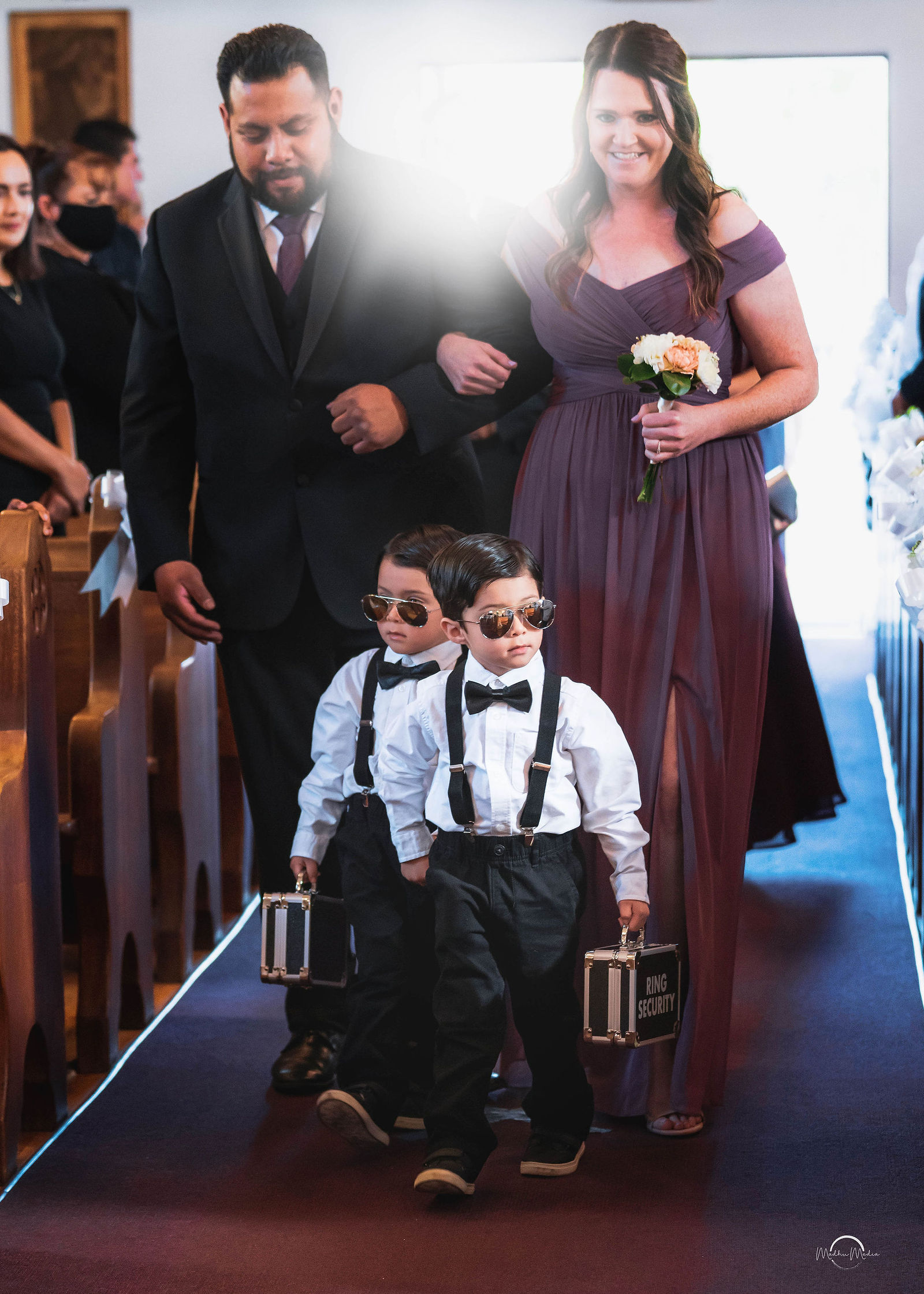 Ring bearers in sunglasses walking the aisle
