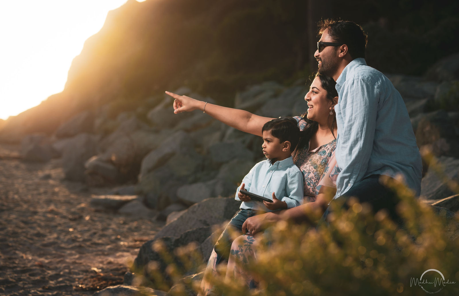 Family pointing to the horizon from the rocks