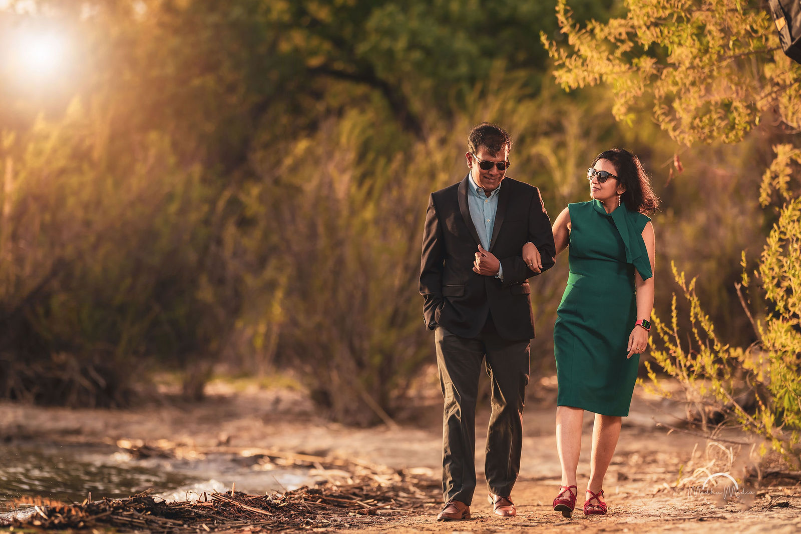 Couple walking arm in arm on a golden trail
