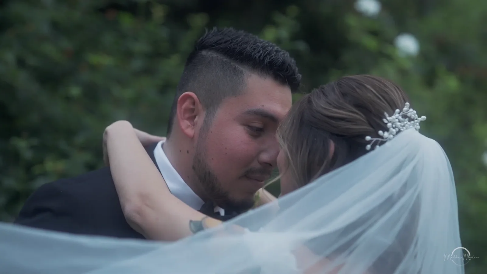 Groom kissing bride beneath her veil, from a Madhu Media wedding film